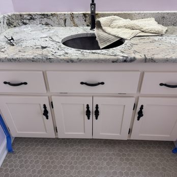 Bathroom vanity with freshly painted white cabinets and granite top