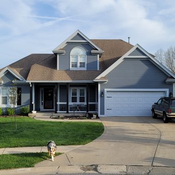 Blue-gray two-story home with covered front porch, freshly painted