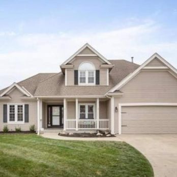 Tan two-story home exterior with fresh paint and landscaped lawn