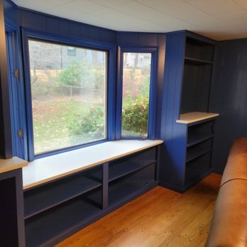Navy window-seat built-ins with bench and open shelving