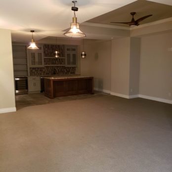 Finished basement rec room with wet bar and pendant lighting