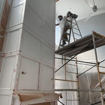 Painter on scaffolding finishing a tall interior column