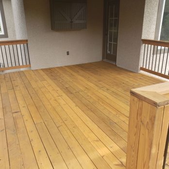 Covered wood porch deck with stained boards and railing