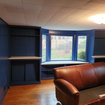 Custom navy built-in shelving beside a bay window