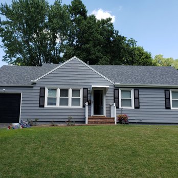 Gray ranch home exterior with black shutters