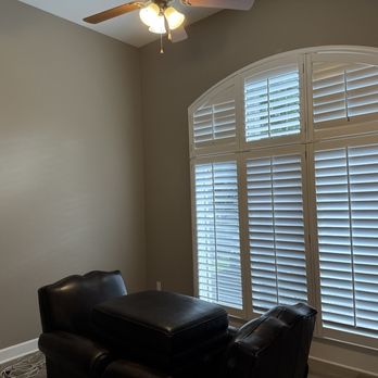 Interior room with plantation shutters and arched window